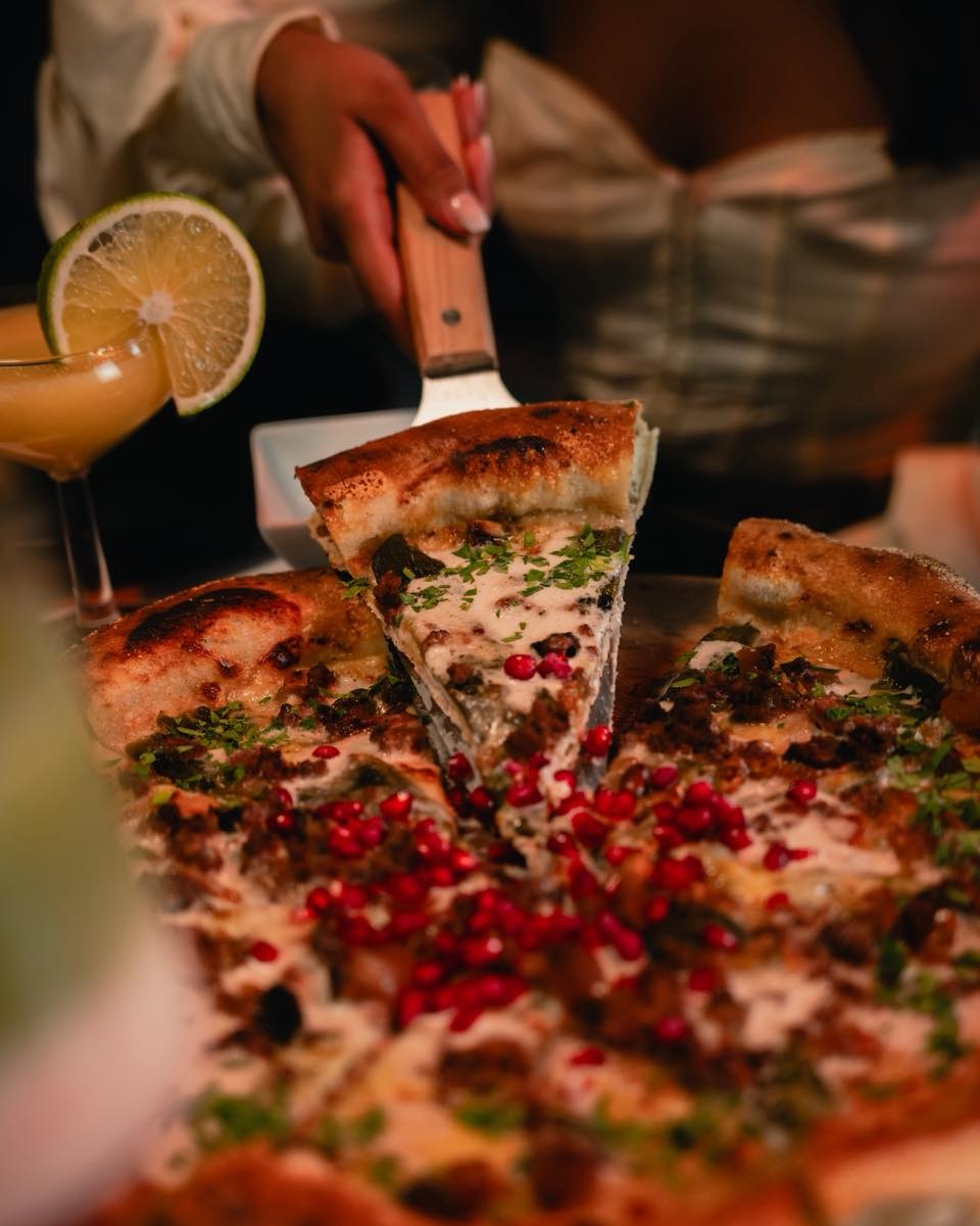 Mesa con pizzas y bebidas en Abraxas