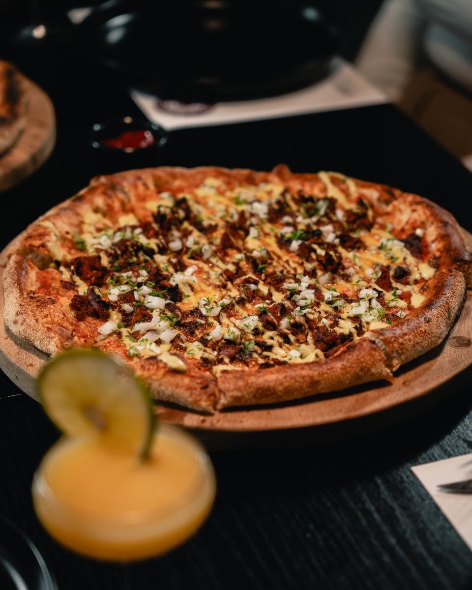 Pizzas y bebidas sobre la mesa